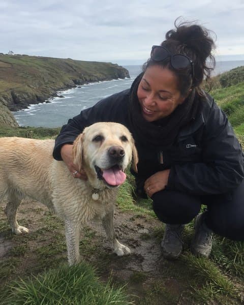 Sonia on a clifftop path with her golden retriever.